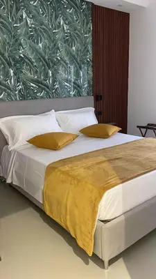 a bed with white sheets and yellow pillows at carpe diem sistina in Rome