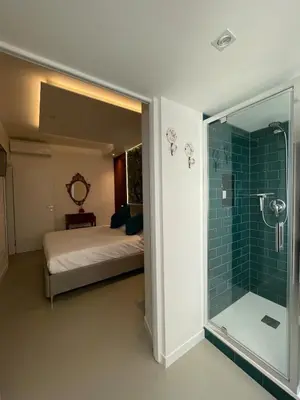 a bedroom with a bed and a glass shower at carpe diem sistina in Rome