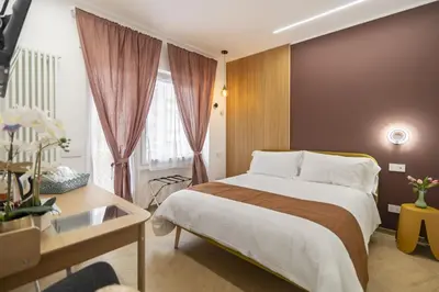 a bedroom with a bed and a desk and a window at cinquepuntozero in Rome
