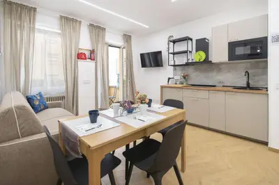 a living room with a table and a kitchen at cinquepuntozero in Rome