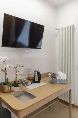 a wooden table with a television on a wall at cinquepuntozero in Rome
