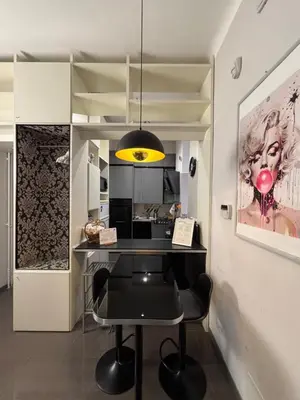 a kitchen with a black table and a yellow light at Cloclò House in Rome