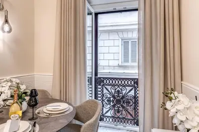 a dining room with a table and chairs and a balcony at Spanish Steps Oasis Suite in Rome