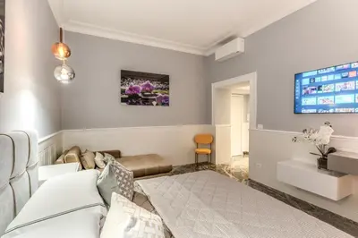 a living room with a couch and a tv at Spanish Steps Oasis Suite in Rome