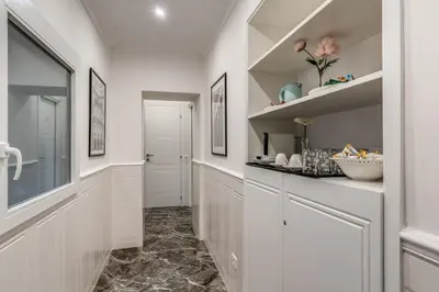 a kitchen with white cabinets and a hallway at Spanish Steps Oasis Suite in Rome