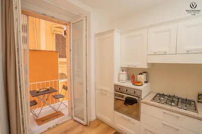 a kitchen with white cabinets and a stove top oven at Valenziani Luxury Central Rome in Rome