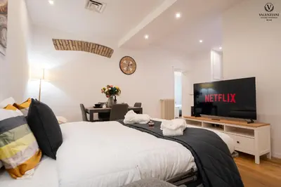 a bedroom with a large bed and a television at Valenziani Luxury Central Rome in Rome