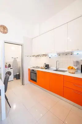 a kitchen with orange cabinets and a sink at Aurelian Crown Central Rome in Rome