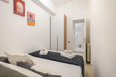 a white bedroom with two towels on a bed at Aurelian Crown Central Rome in Rome