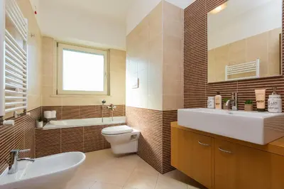 a bathroom with a sink and a toilet and a tub at Boutique Domus Trastevere Family in Rome