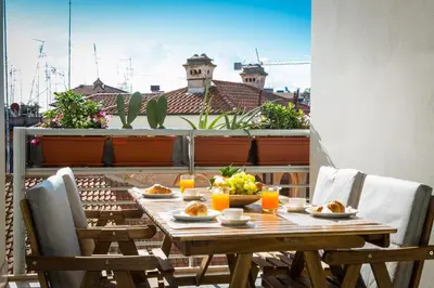 a wooden table on a balcony with food on it at Boutique Domus Trastevere Family in Rome