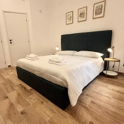 a bedroom with a large bed with a black headboard at Casa Campani 56 in Rome