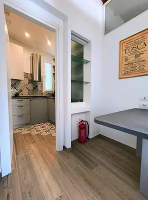 a kitchen with white walls and a table and a counter at ERA Trastevere in Rome