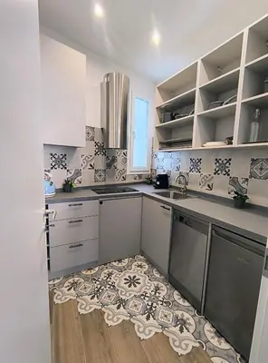 a kitchen with white cabinets and a rug on the floor at ERA Trastevere in Rome