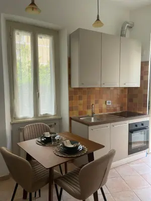a kitchen with a table and chairs and a kitchen with white cabinets at Pigneto Cosmo House in Rome
