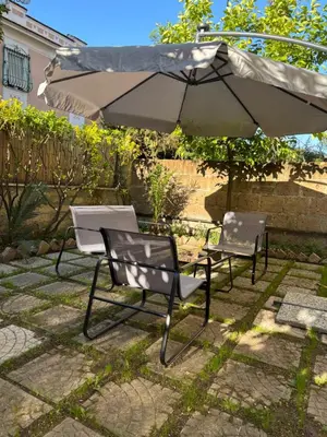 two chairs and an umbrella on a patio at Pigneto Cosmo House in Rome