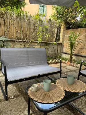 a bench and a table with two cups on it at Pigneto Cosmo House in Rome
