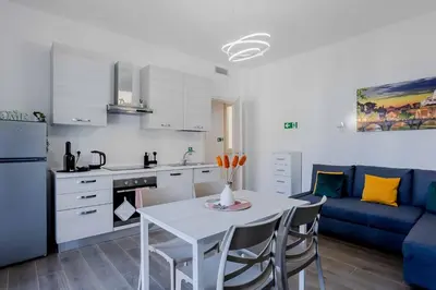 a kitchen and living room with a table and a blue couch at Your dream in Rome San Paolo in Rome