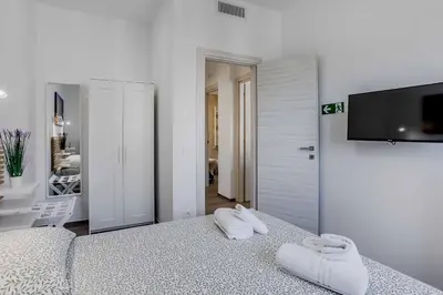 a white bedroom with two white towels on a bed at Your dream in Rome San Paolo in Rome