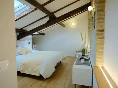 a bedroom with a white bed and wooden ceilings at GG Vatican Townhouse in Rome