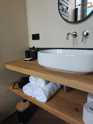 a bathroom with a sink and towels on a shelf at GG Vatican Townhouse in Rome