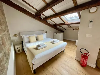 a bedroom with a bed in a room with beams at GG Vatican Townhouse in Rome