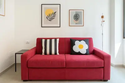 a red couch with two pillows on it in a living room at Ospiti di Jole al Pigneto in Rome