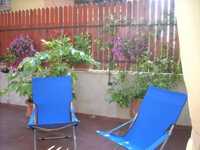 two blue chairs in front of a fence with flowers at Casa Marino Roma in Rome