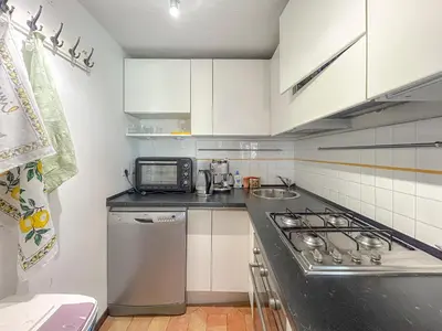 a kitchen with white cabinets and a stove top oven at Attic Castel Sant'Angelo - Pantheon in Rome