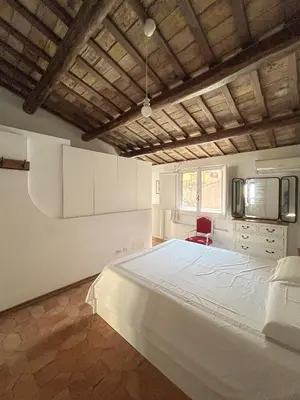 a bedroom with a white bed and a red chair at Attic Castel Sant'Angelo - Pantheon in Rome