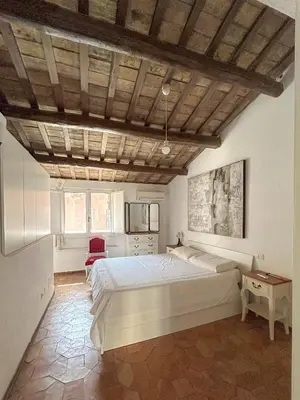 a bedroom with a large bed and a wooden ceiling at Attic Castel Sant'Angelo - Pantheon in Rome