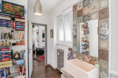 a bathroom with a sink and a book shelf at Dreamy Loft by the Opera Theater in Rome