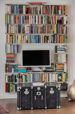 a living room with a tv and a book shelf filled with books at Dreamy Loft by the Opera Theater in Rome