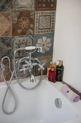 a bath tub with a shower head in a bathroom at Dreamy Loft by the Opera Theater in Rome