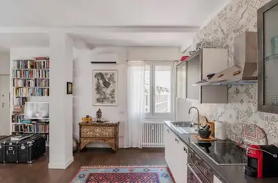 a kitchen with white cabinets and a table and a window at Dreamy Loft by the Opera Theater in Rome