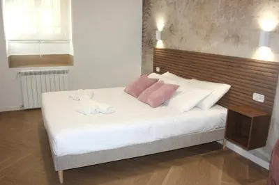a bed with white and pink pillows on it at Domus San Pietro - Elegant stay in Vatican in Rome