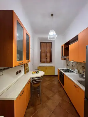 a kitchen with orange cabinets and a white counter top at Paolina lovely apartment in Rome
