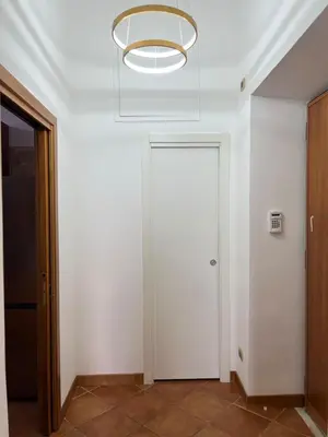 a white hallway with a door and a light at Paolina lovely apartment in Rome