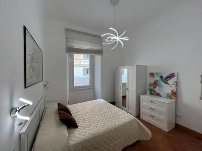 a white bedroom with a bed and a dresser at Paolina lovely apartment in Rome