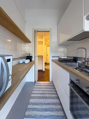 a white kitchen with a sink and a microwave at Casa Anna Vaticano in Rome