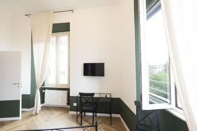 a room with a desk and a tv on a wall at Barberini Grand Retreat with Terrace in Rome