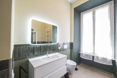 a bathroom with a sink and a toilet and a mirror at Barberini Grand Retreat with Terrace in Rome