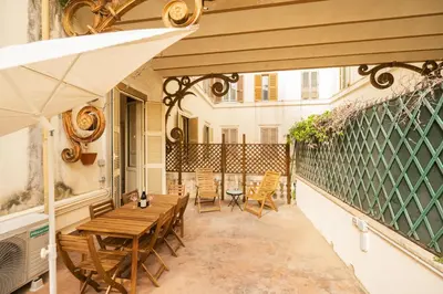 an outdoor patio with a wooden table and chairs at Barberini Grand Retreat with Terrace in Rome