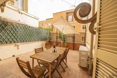 a patio with a wooden table and chairs on a balcony at Barberini Grand Retreat with Terrace in Rome