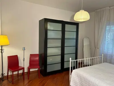 a bedroom with a bed and two red chairs at Cris House Monteverde in Rome