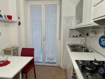 a white kitchen with a sink and a window at Cris House Monteverde in Rome