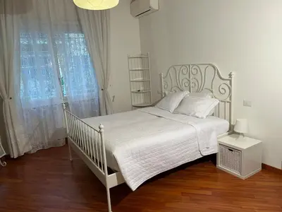 a white bed in a white bedroom with a window at Cris House Monteverde in Rome