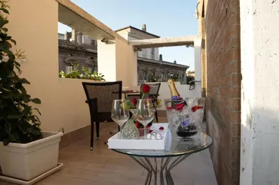 a glass table with wine glasses on a balcony at Terrazza Marco Antonio Luxury Suite in Rome