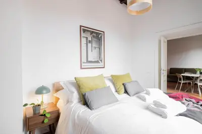 a bedroom with a large white bed with yellow pillows at Fienaroli in Trastevere in Rome