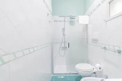 a white bathroom with a shower and a toilet at Fienaroli in Trastevere in Rome